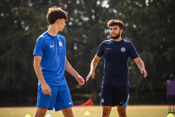 A coach giving an older player individual feedback