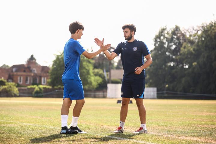 A player high-fiving his coach after a drill
