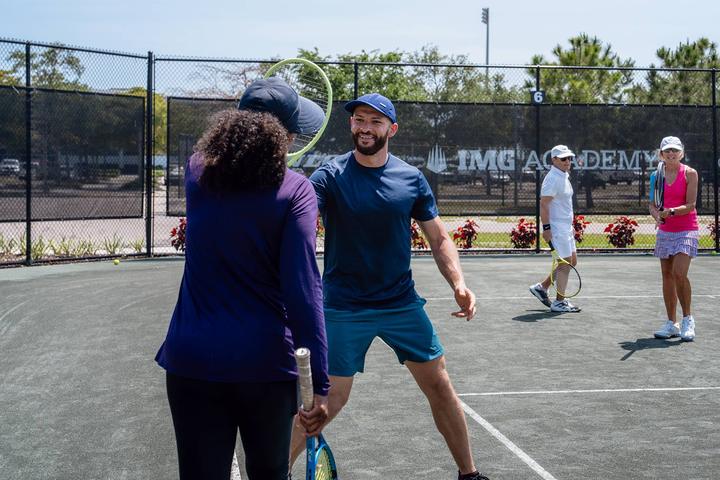 Adult campers in a doubles drill with their coach