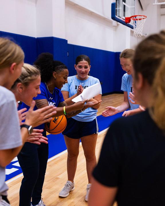 Girls high-fiving their coach during a basketball session