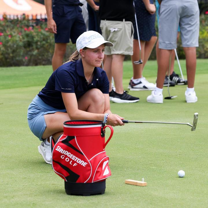 A girl practising putting with an alignment aid
