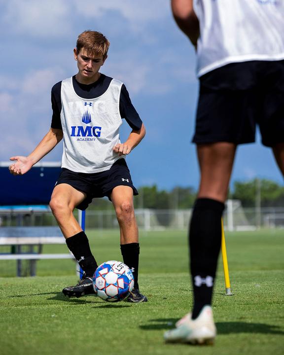 A boy controlling the ball in a passing drill