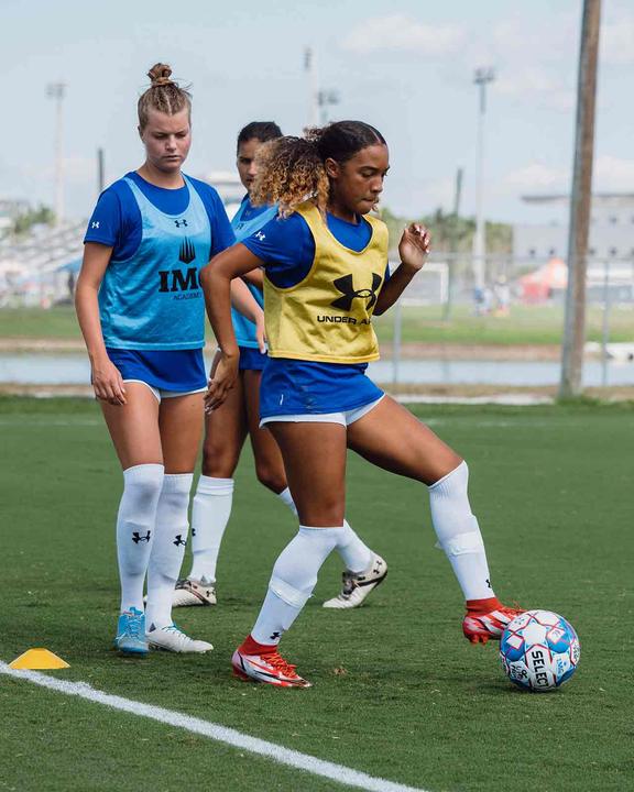 Girls practising ball control on the pitch