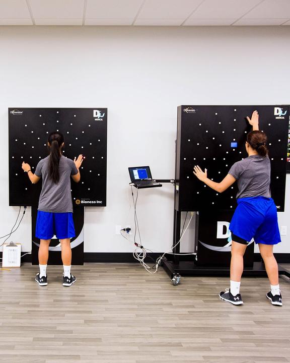 Two girls training reaction speed on light-up reaction boards