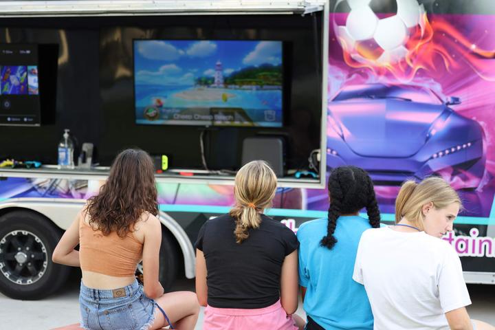 Campers playing video games at a gaming truck on campus