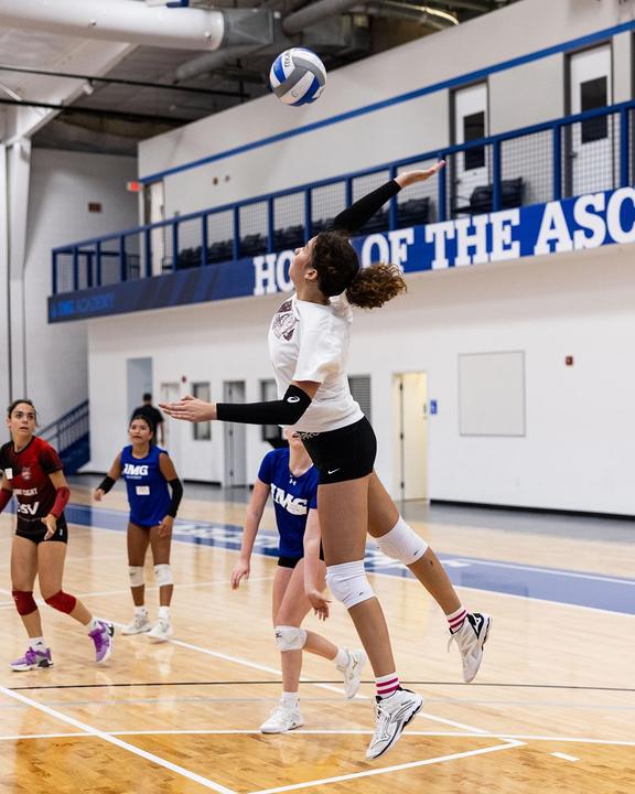 A girl going up for a spike during a scrimmage