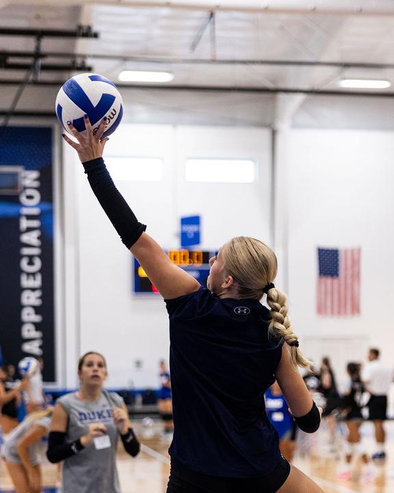 A girl setting the ball during an indoor volleyball session