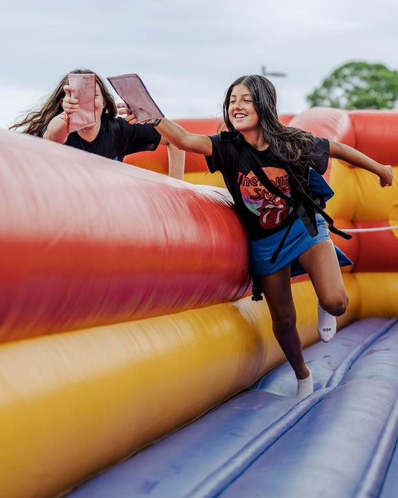 Girls racing across an inflatable obstacle course on campus