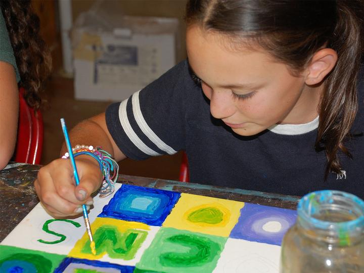 Camper painting colourful squares in the art studio