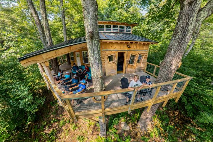 Campers in a large tree house among the trees