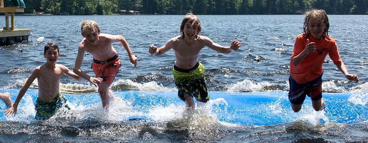 Campers running into the lake