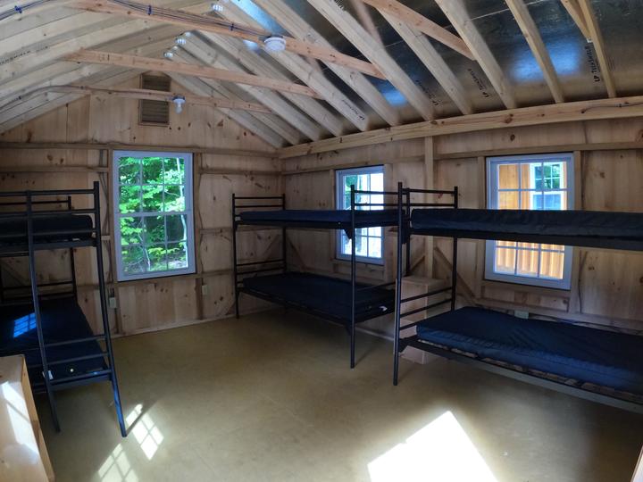 Inside a wooden cabin with bunk beds and big windows
