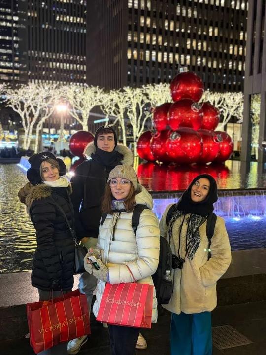 Participants with shopping bags by the giant red Christmas ornaments in Midtown