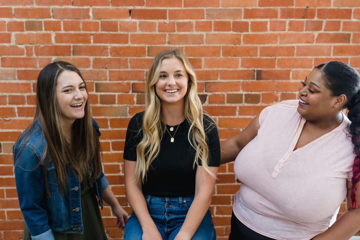 Two students with their host outside a Brooklyn brownstone