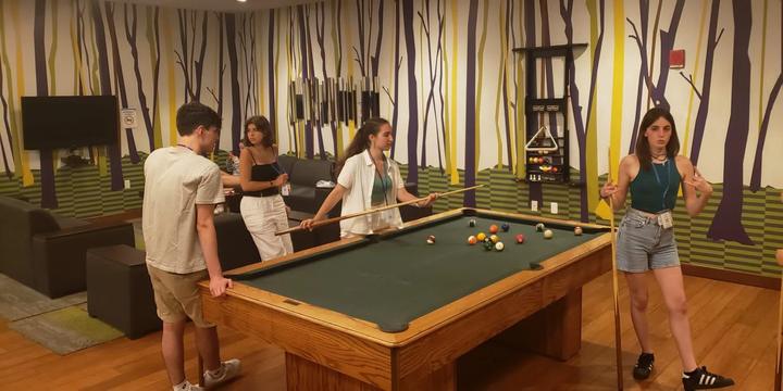 Campers playing pool in the residence lounge