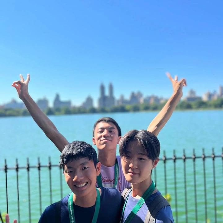 Three campers cheering by the Central Park reservoir