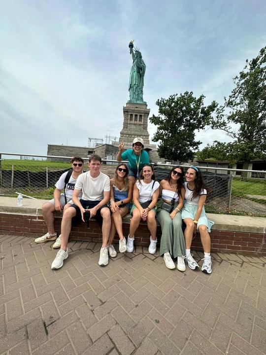 Group sitting in front of the Statue of Liberty