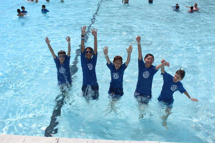 Campers jumping and cheering in the pool