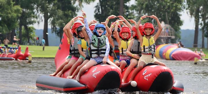 Campers cheering on a towed tube on the lake